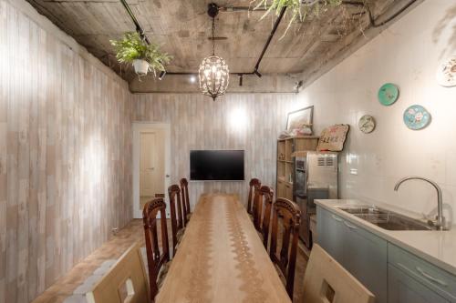 紫品花筑Purple Flower House في آنبينغ: غرفة طعام مع طاولة وكراسي طويلة