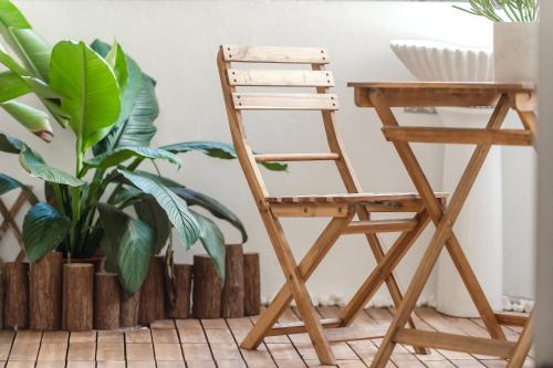 a wooden chair next to a desk in a room with plants at Purple Flower House in Tainan