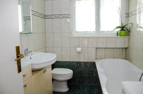 a bathroom with a toilet and a sink and a tub at Apartments with a parking space Split - 11072 in Split