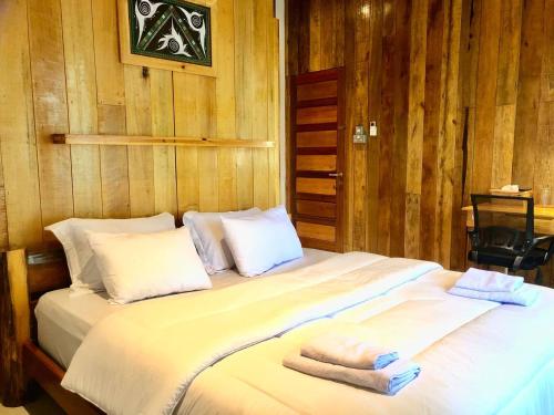 a large white bed with two towels on it at stay KULTURA in Banda Aceh