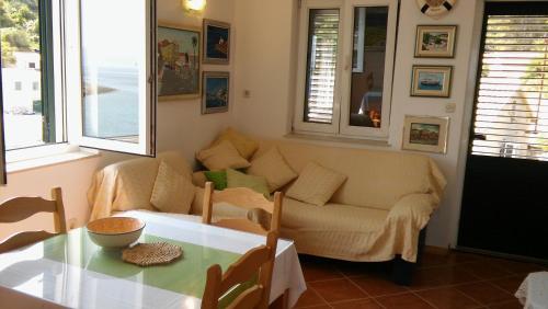 sala de estar con sofá y mesa en Apartments by the sea Cove Donja Kruscica - Donja Krusica, Solta - 11146 en Grohote