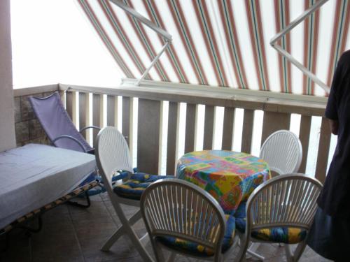 balcón con mesa, sillas, mesa y cama en Apartments by the sea Cove Donja Kruscica - Donja Krusica, Solta - 11146 en Grohote