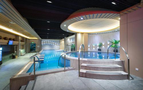 a large swimming pool with a large blue tub at Zhuhai Palm Spring Hotel in Zhuhai