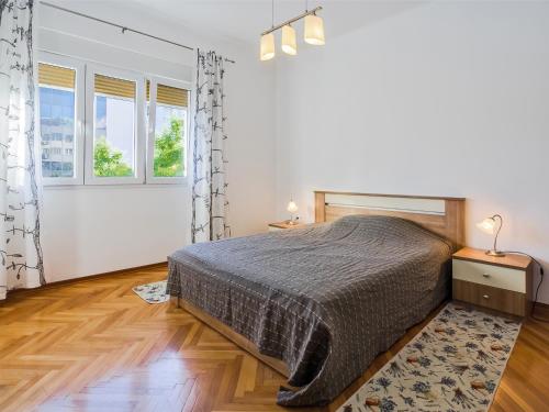 ein weißes Schlafzimmer mit einem Bett und zwei Fenstern in der Unterkunft Apartments with WiFi Split - 11255 in Split