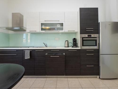 eine Küche mit braunen Schränken und einem Kühlschrank aus Edelstahl in der Unterkunft Apartments with WiFi Split - 11255 in Split