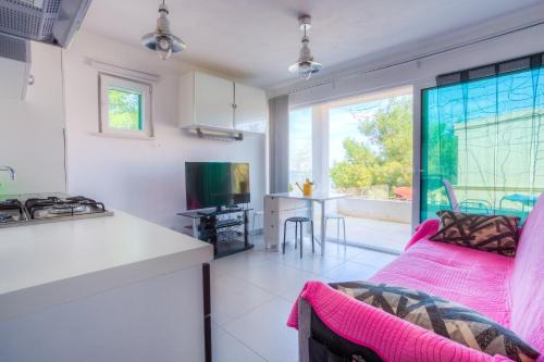 eine Küche und ein Wohnzimmer mit einem rosa Sofa in der Unterkunft Apartments by the sea Rogac, Solta - 11220 in Rogač