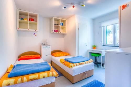 2 Betten in einem kleinen Zimmer mit einem Schreibtisch in der Unterkunft Apartments by the sea Rogac, Solta - 11220 in Rogač