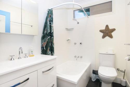 a white bathroom with a sink and a toilet at Bella Luca Pet Friendly Home in Hawks Nest