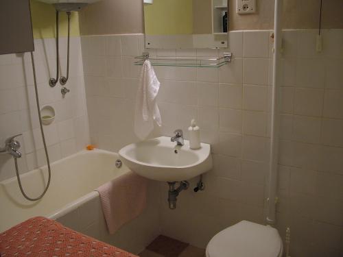 a bathroom with a sink and a tub and a toilet at Apartments with WiFi Split - 11312 in Split