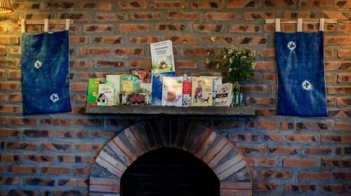 a brick wall with books on a shelf over a brick oven at Sapa Rosie House in Sa Pa