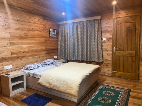 a bedroom with a bed and a wooden wall at Norbu Thungkar Homestay in Darjeeling