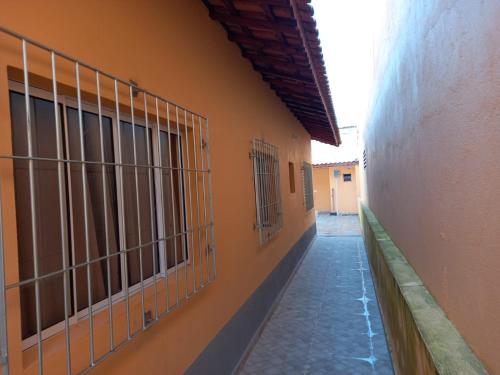 Une allée avec des bars sur le côté du bâtiment dans l'établissement Casa de praia verde mar, à Itanhaém
