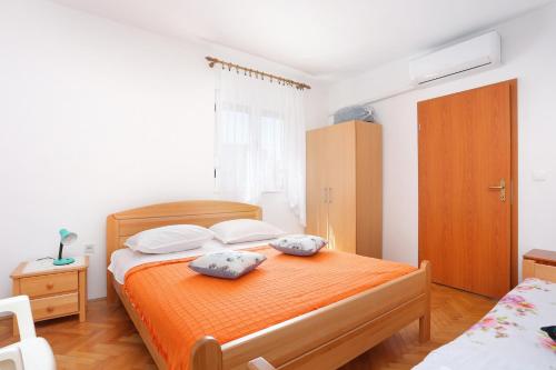 a bedroom with a bed with two pillows on it at Apartments by the sea Vinisce, Trogir - 11029 in Vinišće