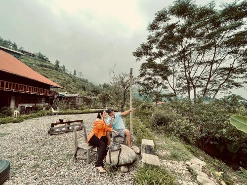 a man and a woman sitting on a bench at Sapa Rosie House in Sa Pa