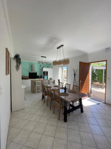 comedor y cocina con mesa y sillas en La Baronnière de Loctudy, en Loctudy