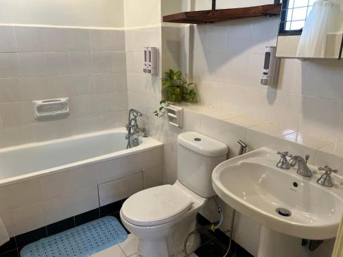 a white bathroom with a toilet and a sink at Sevenseas Marina Crescent in Port Dickson