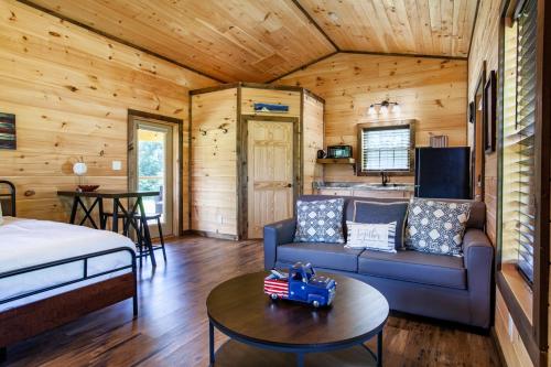 a room with a couch and a bed in a cabin at Patriots Tiny Home w Hot Tub Fire Pit Grill in Sevierville
