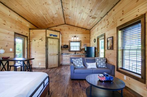Cette chambre comprend un lit, un canapé et une table. dans l'établissement Patriots Tiny Home w Hot Tub Fire Pit Grill, à Sevierville