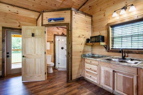 a kitchen with a sink and a toilet in a cabin at Patriots Tiny Home w Hot Tub Fire Pit Grill in Sevierville