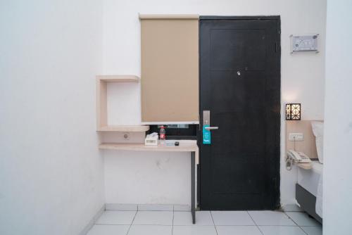 a bathroom with a black door and a sink at Sans Hotel Fif Fa Premiere Malang by RedDoorz in Malang