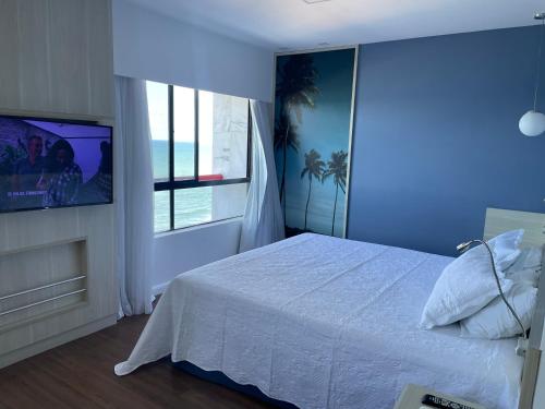 - une chambre bleue avec un lit et une fenêtre dans l'établissement Flat Recife - Boa Viagem, à Récife