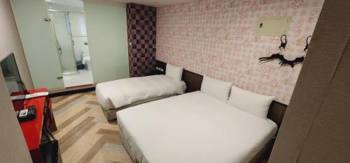 um pequeno quarto com uma cama e um sofá em Ximen Garden Inn em Taipei