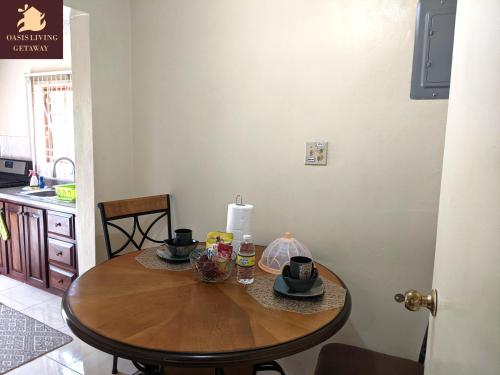 a wooden table in a kitchen with two cups on it at Oasis Living Getaway in Mandeville, Manchester in Mandeville