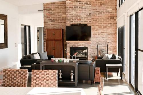 sala de estar con chimenea y pared de ladrillo en Luxury Modern Farm Stay Home in Southern Highlands en Joadja Creek