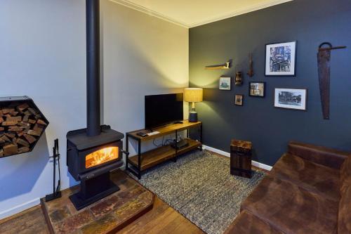 a living room with a fireplace and a television at RAC Margaret River Nature Park in Margaret River Town