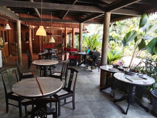 un restaurante con mesas, sillas y plantas en Jimmy Durian Orchard, en Karak