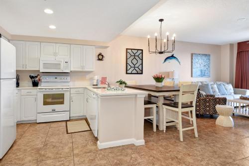 a kitchen and living room with a table and a couch at Modern Beach Highrise-Ocean View-Jacuzzi-Walk In Shower At Ocean Walk Resort Daytona Beach in Daytona Beach