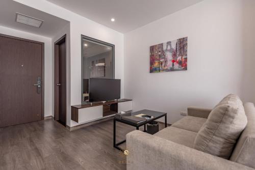 a living room with a couch and a tv at Reyna Hotel Hanoi & Spa in Hanoi