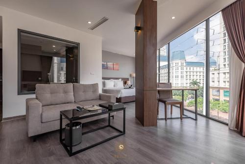 a living room with a couch and a bed and a table at Reyna Hotel Hanoi & Spa in Hanoi