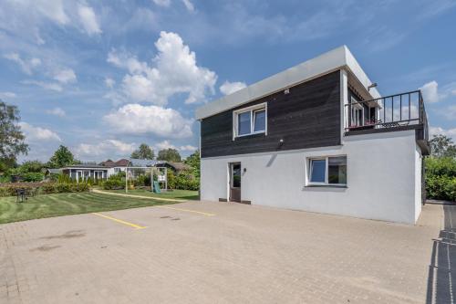 a black and white house with a driveway at Family Garden Apartments with Free Private Parking & Playground in Rīga