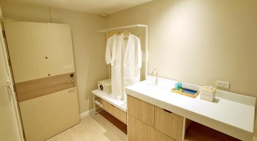 La salle de bains est pourvue d'un lavabo et d'un miroir. dans l'établissement Harolds Evotel Quezon City, à Manille