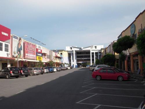una calle de la ciudad con coches aparcados en un estacionamiento en ISLAND TIME MOTEL KUAH en Kuah