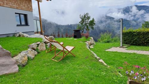 a bench sitting in the grass next to a house at Ferienhaus Oberschindlberg in Lunz am See