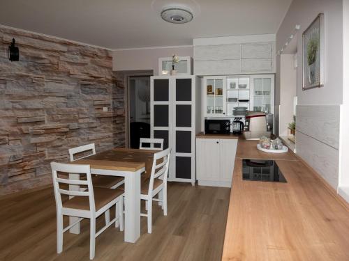 a kitchen and dining room with a table and chairs at Bokor vendégház - Levendula apartman in Szentes