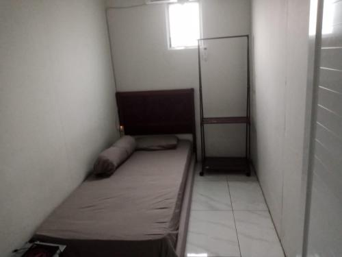Habitación pequeña con cama y ventana en BKT Kozzi en Yakarta