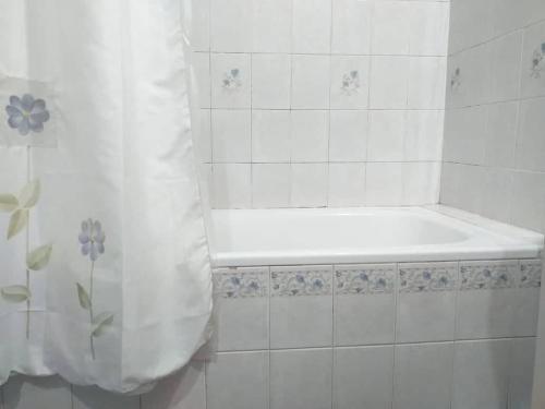 a bathroom with a tub and a shower curtain at Tucuman Centro Departamento in San Miguel de Tucumán