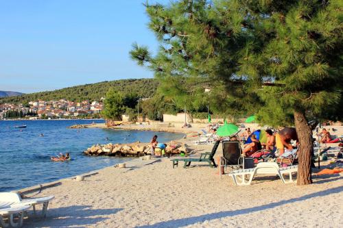 un grupo de personas sentadas en una playa en Apartments with a parking space Trogir - 2046 en Trogir