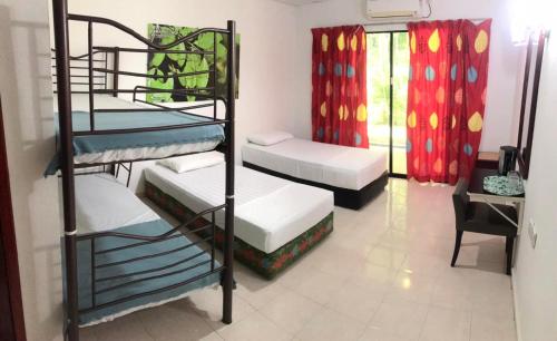 a room with three bunk beds and a desk at Xcape Resort Taman Negara in Kuala Tahan