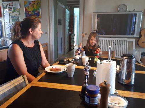 zwei Frauen sitzen an einem Tisch und essen Essen in der Unterkunft Thisted Øst Bed & No Breakfast in Thisted