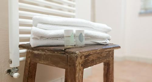 a pile of towels sitting on top of a wooden stool at A Casa di Anna in Cortemilia