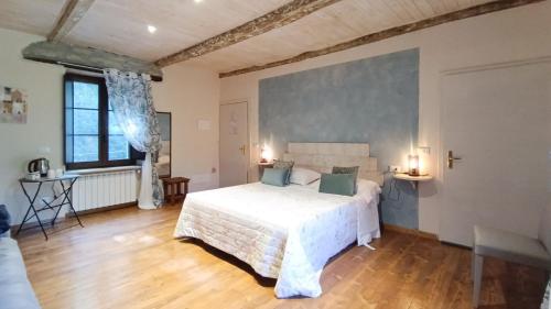 a bedroom with a large white bed in a room at A Casa di Anna in Cortemilia