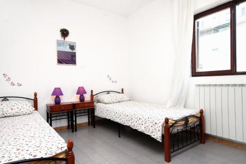 Un dormitorio con 2 camas y una mesa con lámparas. en Apartments by the sea Umag - 2528 en Umag