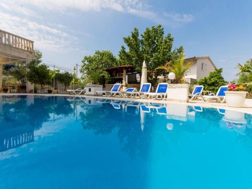 a swimming pool with lounge chairs and blue water at Villa Stil in Trogir