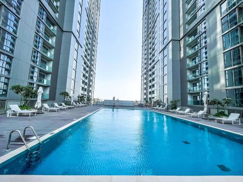 a large swimming pool in the middle of two tall buildings at STAY BY LATINEM Luxury 2BR Holiday Home CV B2513 near Burj Khalifa in Dubai