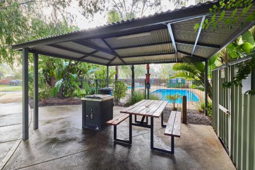 a pavilion with a picnic table and a grill at RAC Busselton Holiday Park in Busselton