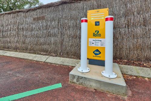 a yellow gas pump sitting next to a fence at RAC Busselton Holiday Park in Busselton
